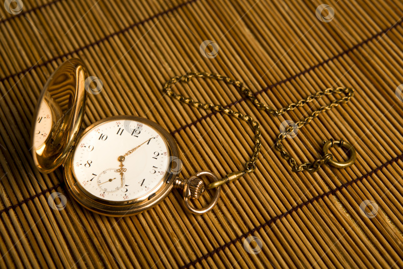 Скачать Золотые карманные часы на бамбуковых ковриках фотосток Ozero