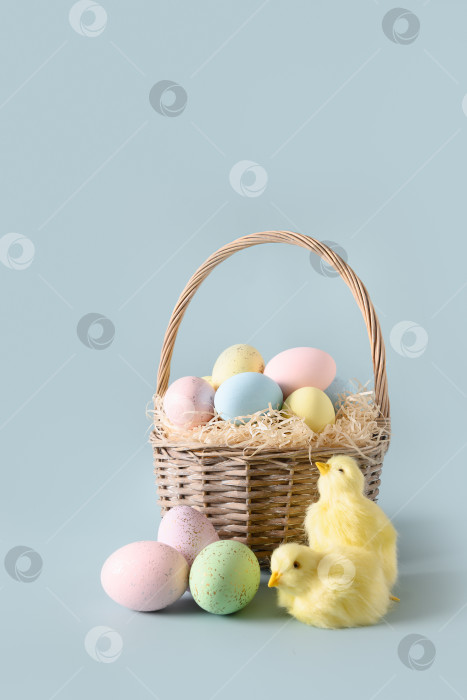 Скачать Пасхальная плетеная корзина с яйцами пастельных тонов для счастливого праздника. фотосток Ozero