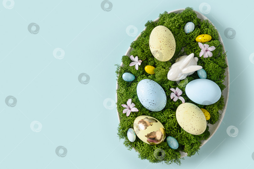 Скачать Пасхальная композиция своими руками в тарелке для праздничного стола с кроликом, яйцами, мхом и весенними цветами. фотосток Ozero