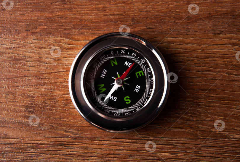 Скачать туристический компас, лежащий на деревянном столе фотосток Ozero