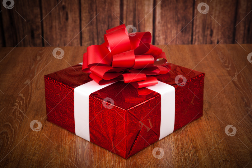 Скачать одна большая красная подарочная коробка на деревянной подставке фотосток Ozero