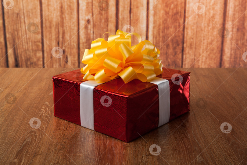 Скачать одна большая красная подарочная коробка на деревянной подставке фотосток Ozero
