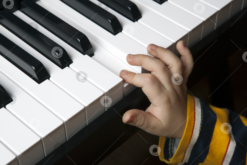 Скачать рука маленького мальчика на клавишах пианино фотосток Ozero