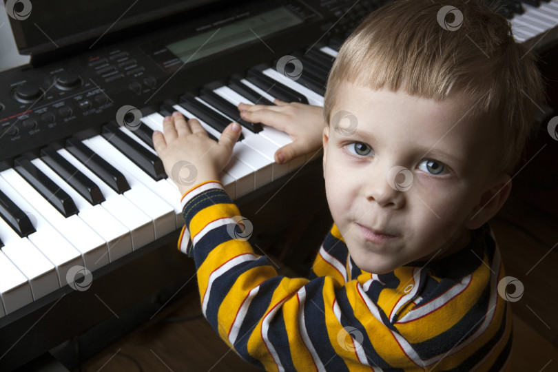 Скачать талантливый маленький мальчик сидит за пианино фотосток Ozero