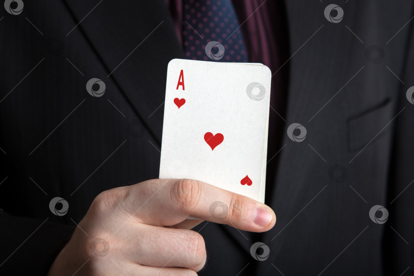 Скачать мужчина держит в руках колоду карт и туза червей фотосток Ozero