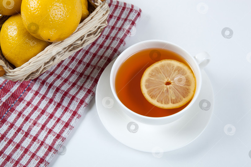 Скачать Натюрморт из свежих лимонов в корзинке и чашки чая фотосток Ozero