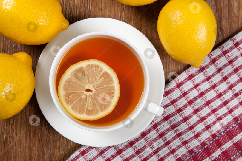 Скачать Натюрморт из свежих лимонов на деревянном столе с чашкой чая фотосток Ozero