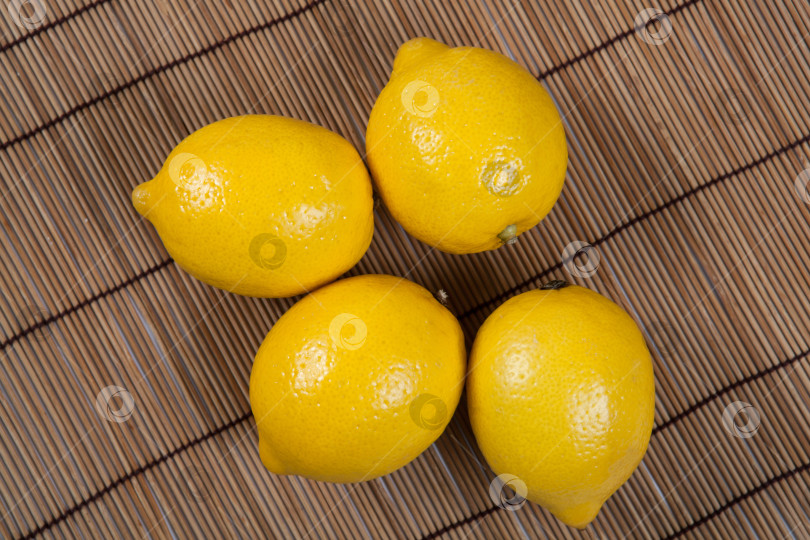 Скачать Натюрморт из свежих лимонов на бамбуковой салфетке фотосток Ozero