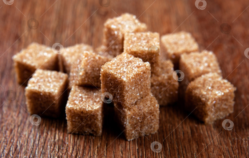 Скачать кубики коричневого сахара выложите на деревянную поверхность фотосток Ozero