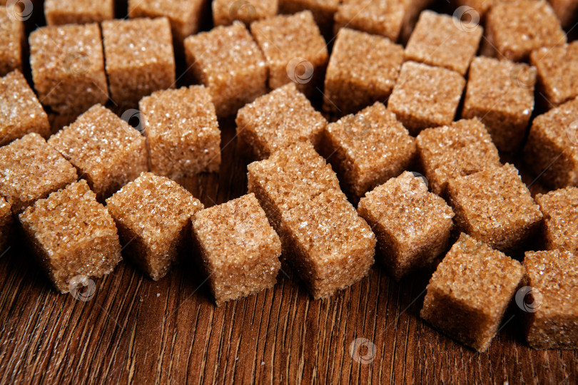 Скачать фон из кубиков коричневого сахара на деревянном столе фотосток Ozero