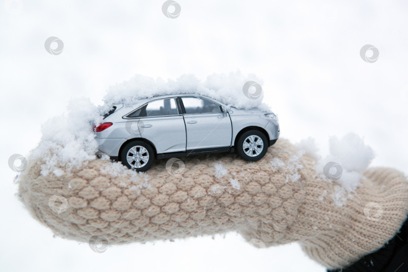 Скачать девушка держит в руке модель автомобиля со снегом фотосток Ozero