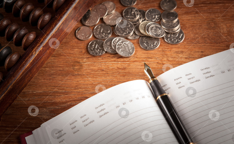 Скачать авторучка и ежедневник на столе со счетами и рублевыми монетами фотосток Ozero