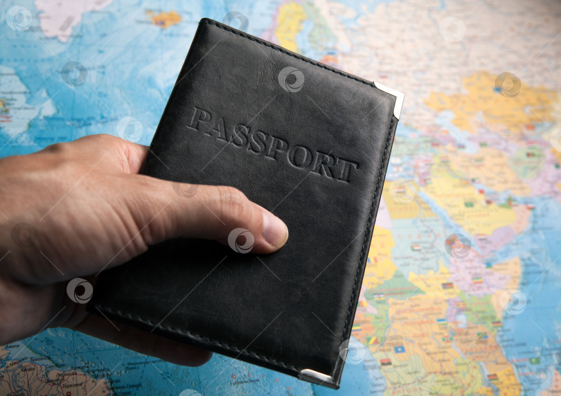 Скачать паспорт гражданина в руке человека на фоне карты мира фотосток Ozero