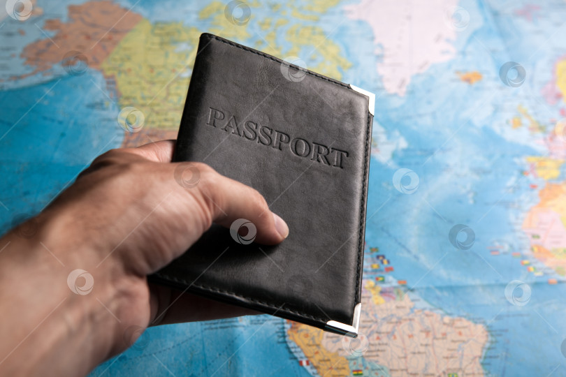 Скачать паспорт гражданина в руке человека на фоне карты мира фотосток Ozero