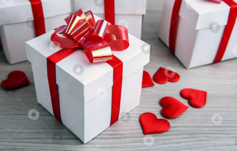 Скачать белая подарочная коробка на сером фоне и текстильные сердечки в форме сердца фотосток Ozero