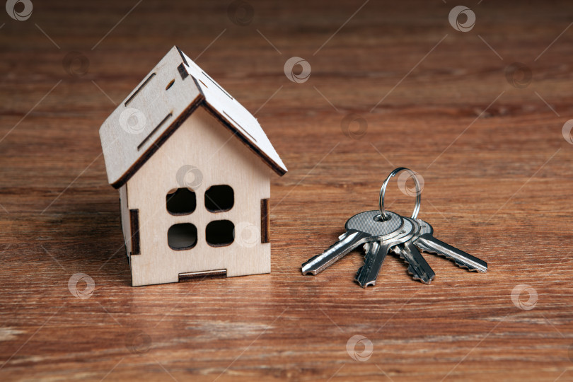 Скачать деревянный миниатюрный домик и ключ от двери на деревянном фоне фотосток Ozero