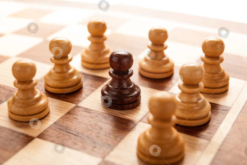Скачать черная шахматная пешка в окружении белых шахматных пешек фотосток Ozero