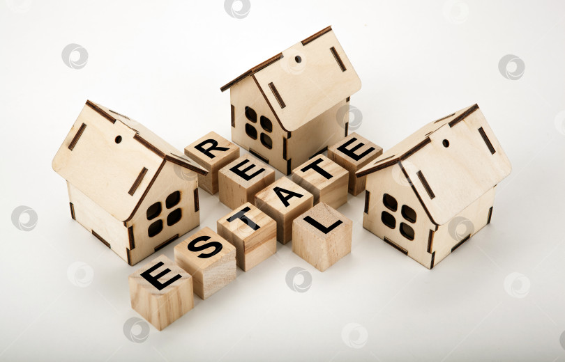 Скачать деревянные кубики с надписью недвижимость в виде кроссворда с тремя миниатюрными домиками фотосток Ozero