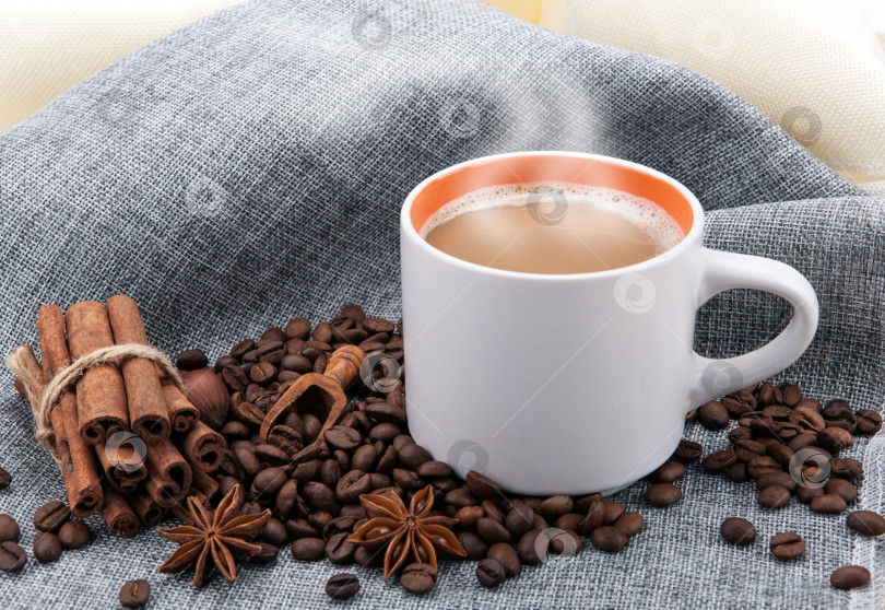 Скачать чашка кофе с молоком на цветной салфетке и обжаренные кофейные зерна крупным планом фотосток Ozero