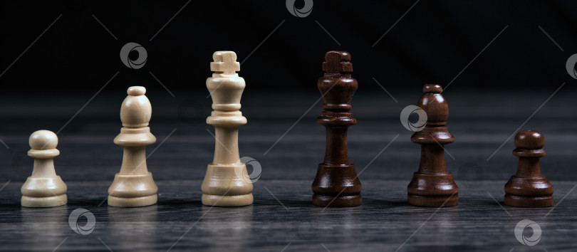 Скачать шахматные короли и различные шахматные фигуры, расположенные в ряд на деревянном фоне фотосток Ozero