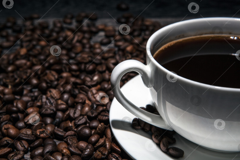 Скачать чашка горячего кофе и обжаренных кофейных зерен на деревянном столе фотосток Ozero
