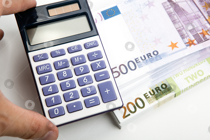 Скачать калькулятор в руке и пачка банкнот в 500 и 200 евро крупным планом фотосток Ozero