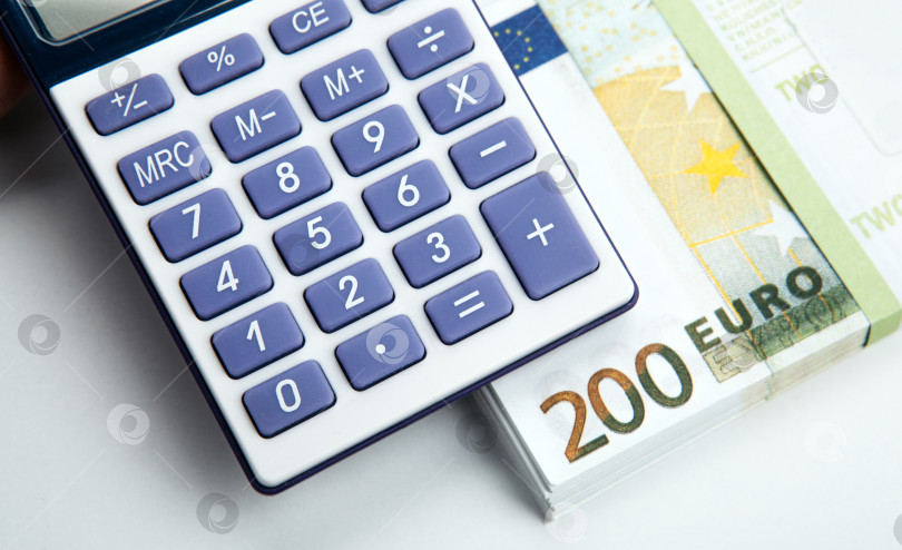 Скачать деловой натюрморт из калькулятора и пачки банкнот достоинством 200 евро фотосток Ozero