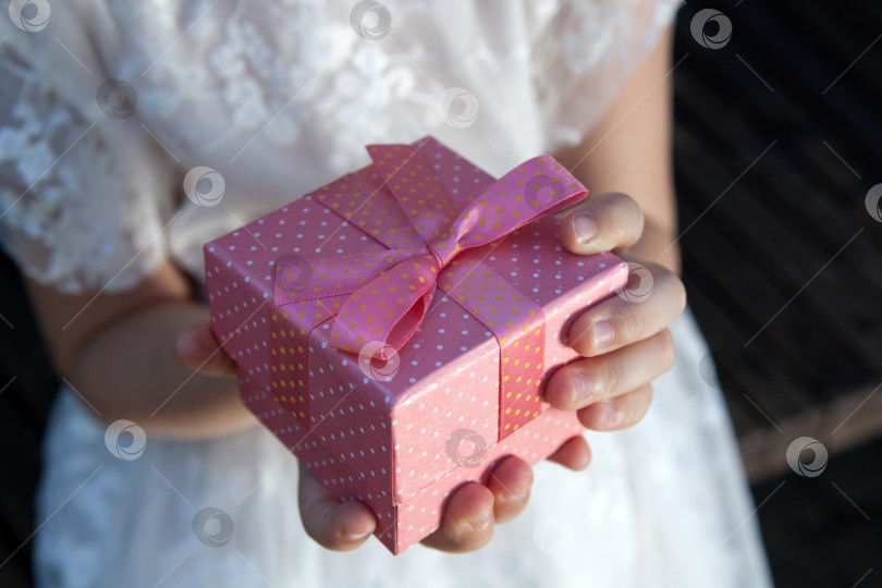Скачать розовая подарочная коробка в детских ладошках фотосток Ozero