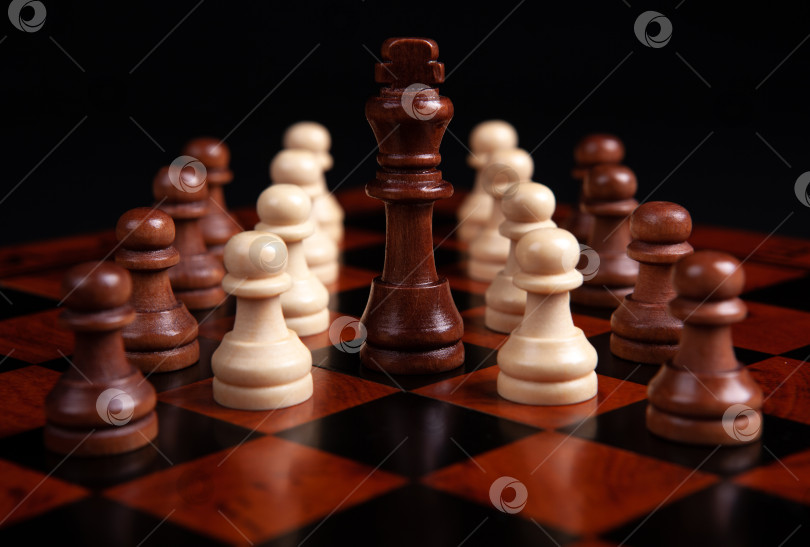 Скачать шахматные пешки и король на доске на черном фоне фотосток Ozero