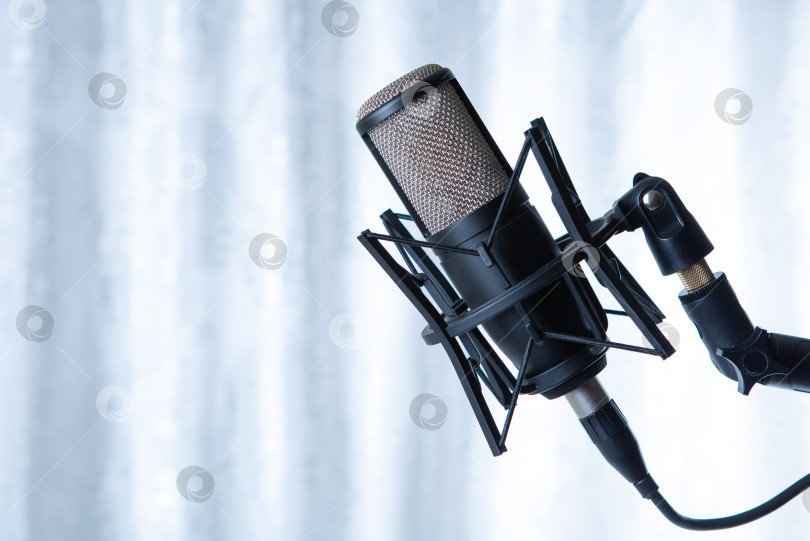 Скачать студийный черный конденсаторный микрофон на фоне серых штор фотосток Ozero