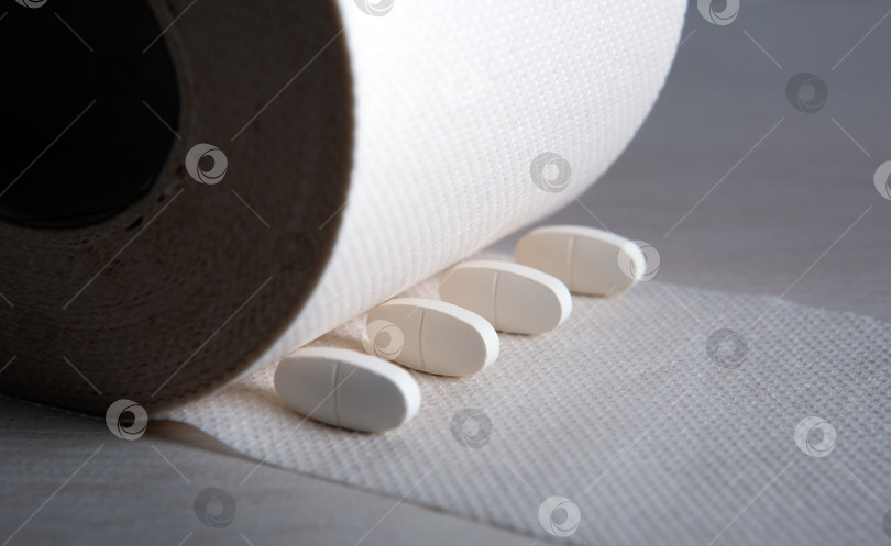 Скачать рулон туалетной бумаги с белыми таблетками на столе фотосток Ozero