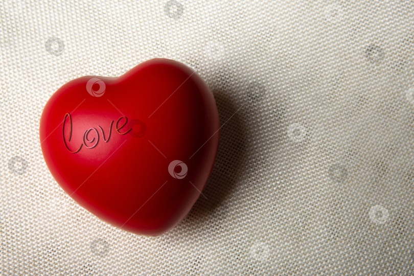 Скачать Большое красное сердце с надписью love на текстильном фоне фотосток Ozero