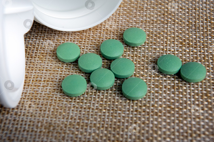Скачать круглые зеленые таблетки в баночке на салфетке фотосток Ozero