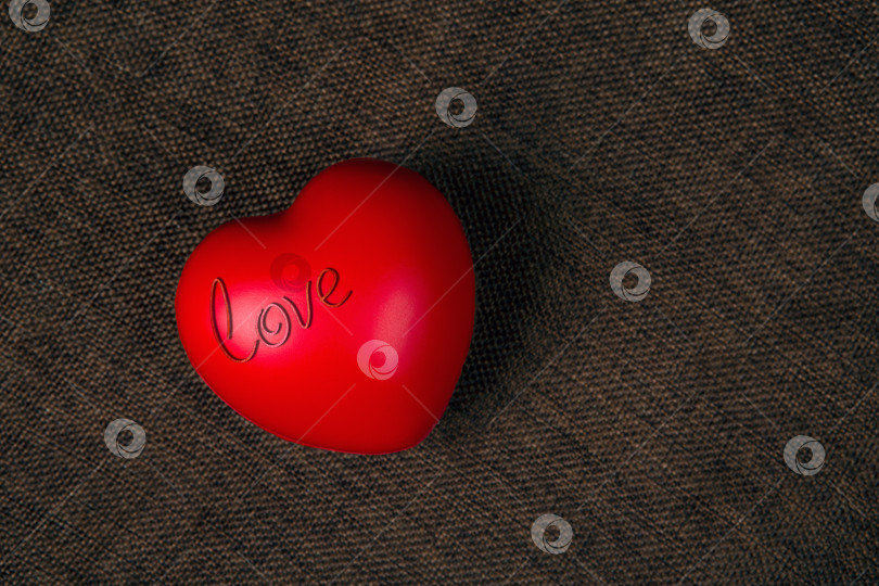 Скачать Большое красное сердце с надписью love на текстильном фоне фотосток Ozero