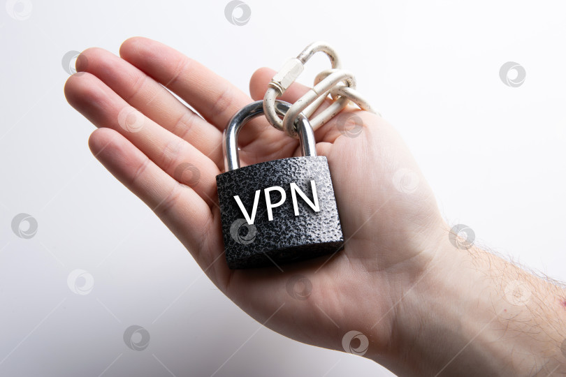 Скачать навесной замок со стальной цепочкой с надписью VPN в человеческих руках фотосток Ozero