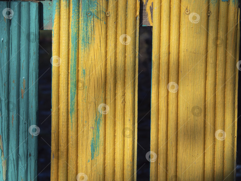Скачать Текстурный фон деревянных желтых и синих досок. Деревянная поверхность имеет желто-голубой цвет, текстуру или фон.  Потертые полосатые старые крашеные доски фотосток Ozero