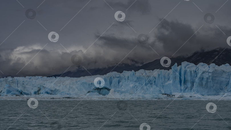 Скачать Стена голубого льда с трещинами и расселинами возвышается над бирюзовым озером. фотосток Ozero
