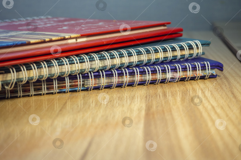 Скачать Записные книжки на поверхности деревянного стола. Сложенные блокноты на деревянном столе выборочный фокус фотосток Ozero