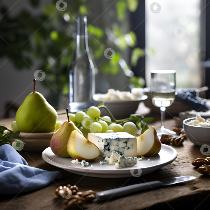 Скачать Тарелка с грушами и голубым сыром на деревянном столе в деревенском стиле, интерьер кухни. Винная закуска. Свежая нарезанная груша подается с голубым сыром и виноградом на керамической тарелке на кухонном столе перед окном фотосток Ozero