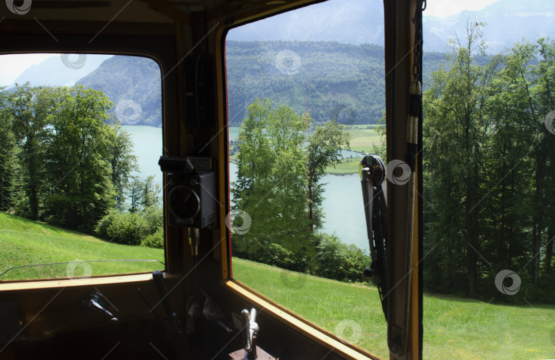 Скачать Вид из окон движущегося поезда на горную местность. Прекрасные пейзажи в Швейцарских Альпах. фотосток Ozero