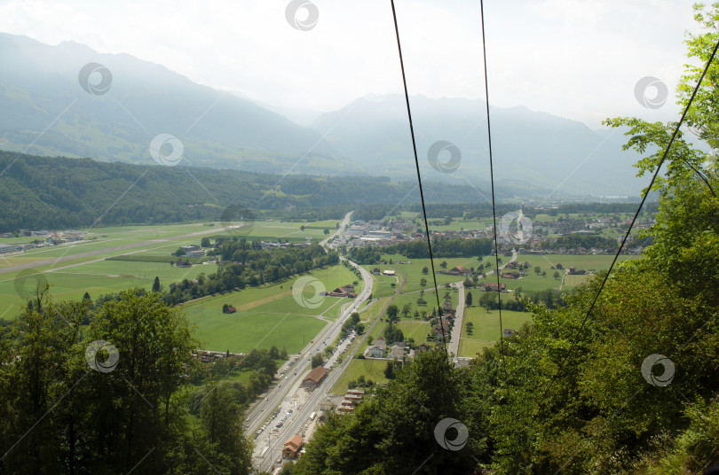 Скачать Вид с высоты птичьего полета на маленький европейский зеленый городок. Поднимитесь в горы. Швейцария, Европа. фотосток Ozero