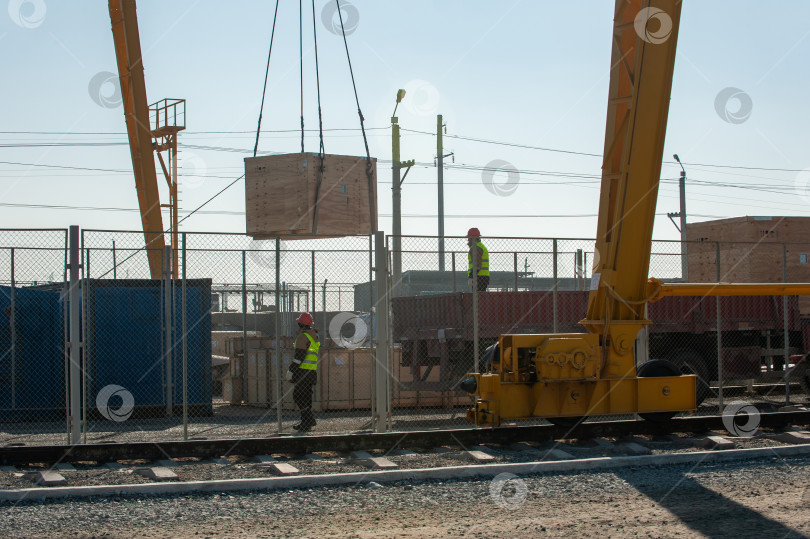 Скачать Автокран на железнодорожных путях загружает строительные материалы фотосток Ozero