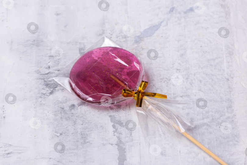 Скачать Розовый леденец на палочке на текстурированном фоне фотосток Ozero