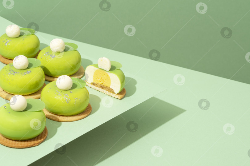 Скачать На деревянном столе стоит блюдо с разнообразными зелеными пончиками фотосток Ozero
