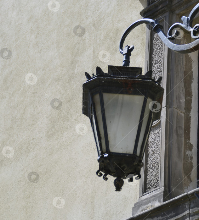 Скачать Древний уличный фонарь крупным планом на фоне каменной стены. Европа. фотосток Ozero