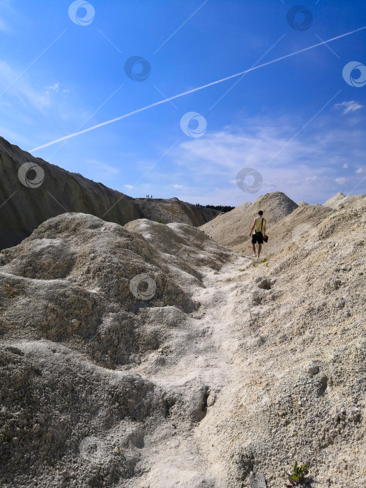 Скачать Одинокий мужчина, идущий по горной песчаной дороге. фотосток Ozero