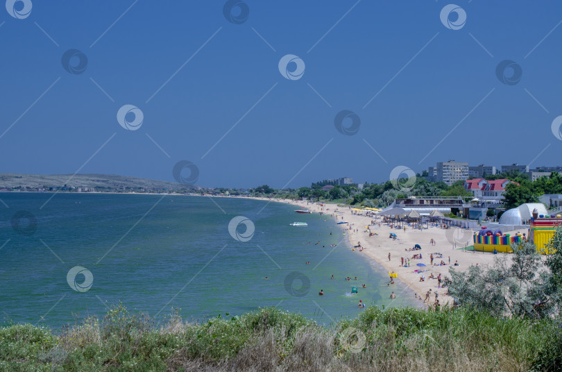 Скачать Прибрежный курортный городок. Пляж с белым песком и голубой водой. Щелкино, Крым. фотосток Ozero