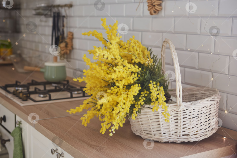 Скачать Весенние цветы мимозы в белой корзине на кухне. Внутренняя отделка фотосток Ozero