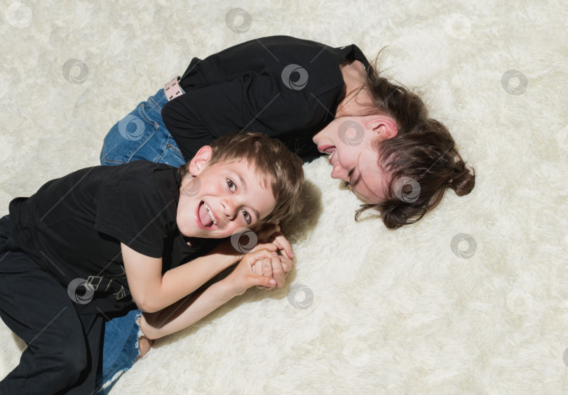 Скачать Брат и сестра играют на кровати в новой махровой накидке фотосток Ozero
