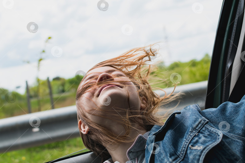 Скачать Молодая девушка выглядывает из открытого окна автомобиля фотосток Ozero